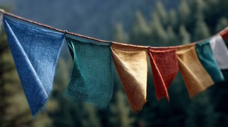 Close-up of five Tibetan prayer flags representing blue, white, red, green, and yellow elements.